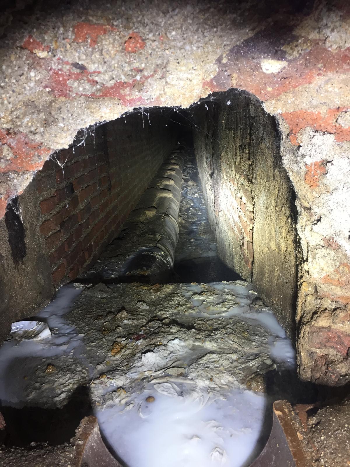 Operario de Grupozo realizando limpieza de tubo en galería subterránea